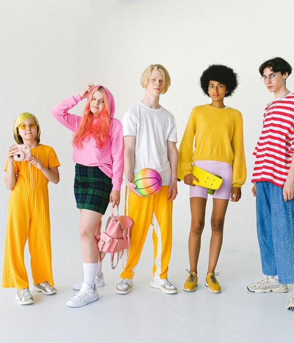 Diverse group of people in a bright, modern studio preparing for a yoga session.